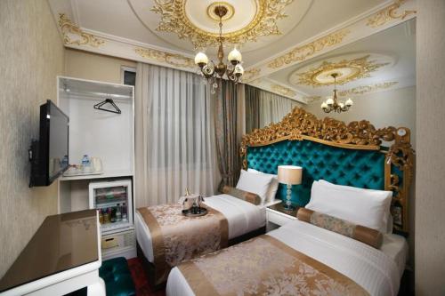 a hotel room with two beds and a chandelier at White Monarch Hotel in Istanbul