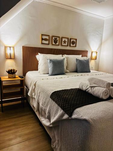 a bedroom with a large bed with two pillows at Suítes Viver Arraial do Cabo in Arraial do Cabo