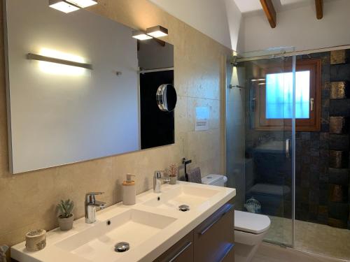 a bathroom with a sink and a toilet and a mirror at Casa Laura by Sun & Sea Homes in Moraira