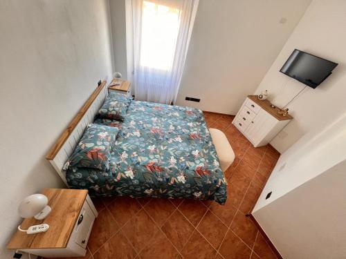 a small room with a bed and a television at Casa Nausicaa in Pergine Valsugana