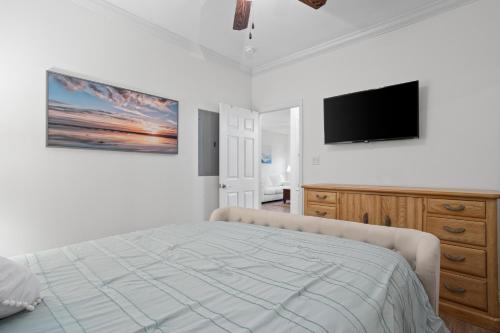 a bedroom with a bed and a flat screen tv at Steps from the Sand and Town Green - 2BR Coastal Retreat in Long Beach
