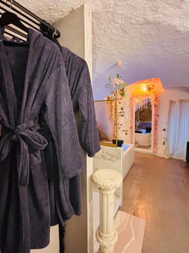 a bathroom with a robe hanging on a wall at La suite des cœurs cachés in Valserres