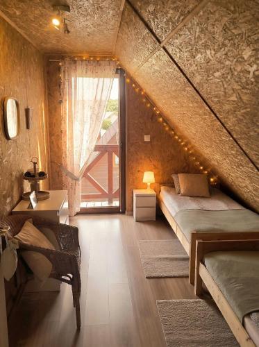 a bedroom with two beds and a large window at Cichosza Miłomłyn in Miłomłyn