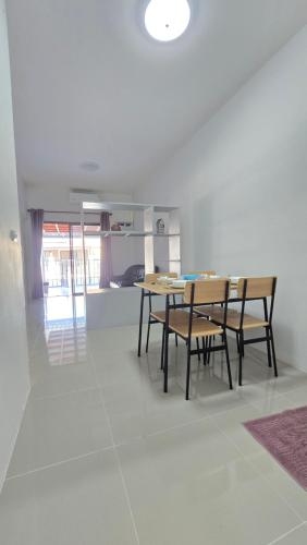 a dining room with a table and chairs at Joyful House Naiyang beach in Thalang