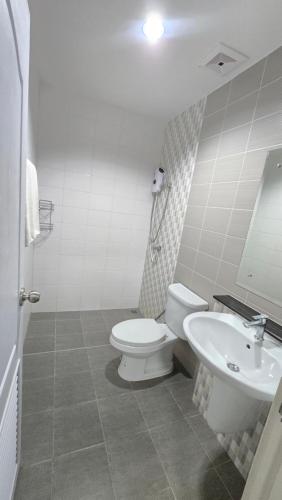 a white bathroom with a toilet and a sink at Joyful House Naiyang beach in Thalang