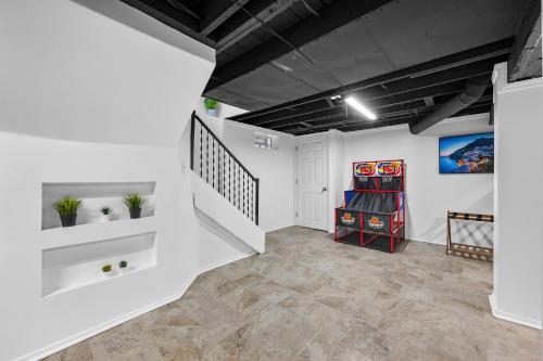 a living room with white walls and a staircase at Quiet Detroit 3BR | Near Downtown + WiFi in Detroit