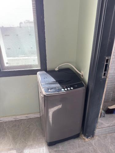 un petit réfrigérateur dans une pièce avec une fenêtre dans l'établissement Résidence NDAR, à Saint-Louis