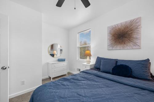 a bedroom with a blue bed and a mirror at Quiet Detroit 3BR | Near Downtown + WiFi in Detroit