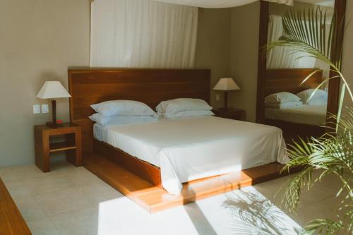 a bedroom with a large bed and a mirror at Secret Garden Hideaway in Balcheil