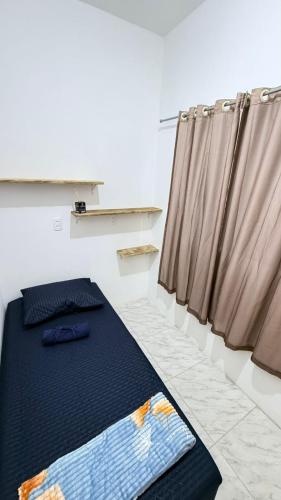 a bedroom with a bed and a curtain at Republica Fusinato in Itajaí