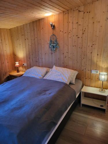 a bedroom with a large bed with wooden walls at Vonarland hús með einu svefnherbergi in Stokkseyri