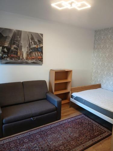 a living room with a couch and a bed at Biedronka- samodzielny apartament dla 3 osób z miejscem parkingowym in Sopot