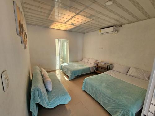 a room with two beds and a couch in it at PLAYABRISAMAR in San Antero