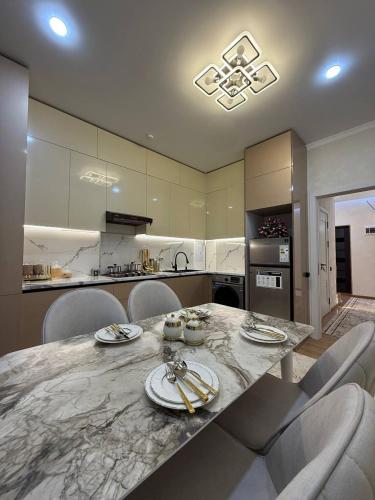 a kitchen with a large marble table with chairs at Silk Road Retreat City Center in Bukhara