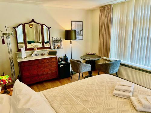 a bedroom with a bed and a desk and a mirror at Bed and Breakfast Rotterdam in Rotterdam