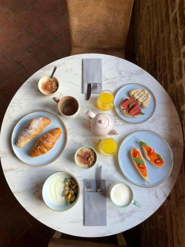a white table with plates of food on it at B&B Osteria Del Vicario in Certaldo