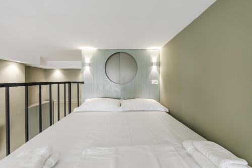a bedroom with a large white bed with a mirror at Amel's Rooms by PikHost in Tirana