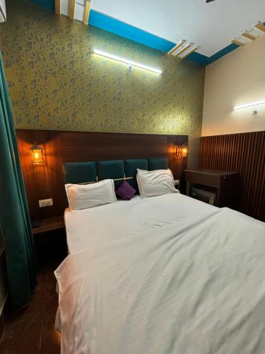 a bedroom with a large bed with white sheets at Himalayan Stayz in Rishīkesh
