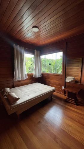 a bedroom with a large bed and a window at Casa Guarapari in Guarapari