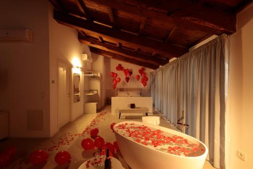 a bathroom with a bath tub with red balloons on the floor at Palazzo Simonetti in Ascoli Piceno