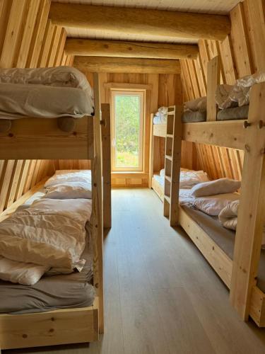 a room with three bunk beds in a log cabin at Gluba Lavvo in Harkmark