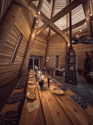 a long wooden table in a room with wooden ceilings at Gluba Lavvo in Harkmark