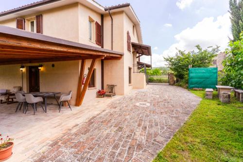 a patio of a house with a table and chairs at house Al Cascinale in San Severino Marche
