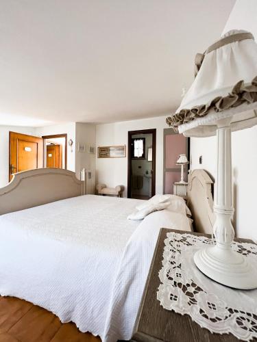 ein weißes Schlafzimmer mit einem Bett und einem Tisch in der Unterkunft B&B Nero Buono in Cori