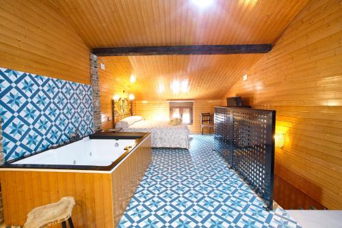 a room with a tub and a bed in a room at Cuencaloft Casa Rural Eloy in Carboneras de Guadazaón