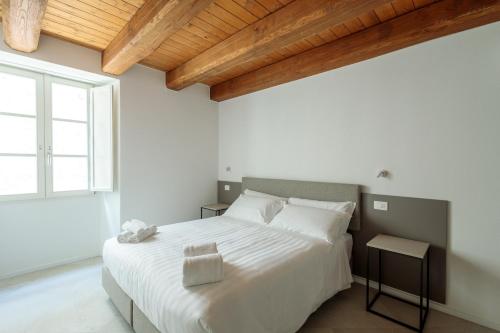 a bedroom with a large white bed and a window at Palazzo Simonetti in Ascoli Piceno