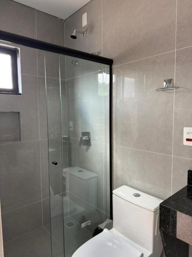 a bathroom with a toilet and a glass shower at Arena Bitz in Pato Branco