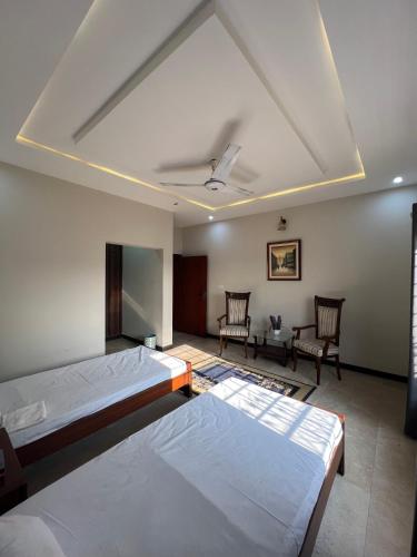 a large room with two beds and two chairs at Urban Villa in Islamabad