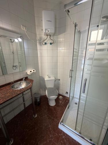 a bathroom with a shower and a toilet and a sink at Tamonante rooms in Gran Tarajal