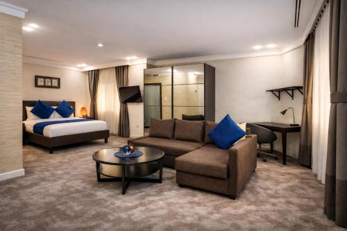 una camera d'albergo con un divano e un letto di Al Basem Hotel ad Amman