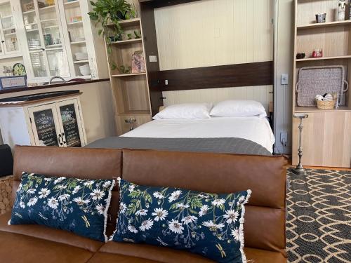 a bedroom with a bed and a leather couch at Romantic Studio Apt in Historic Downtown Savannah in Savannah