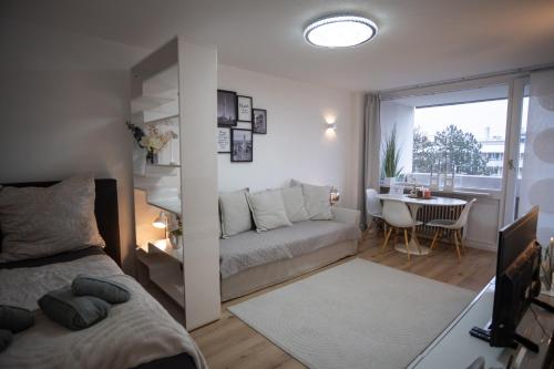 a living room with a couch and a table at Cozy apartment with pool I U-Bahn in Munich