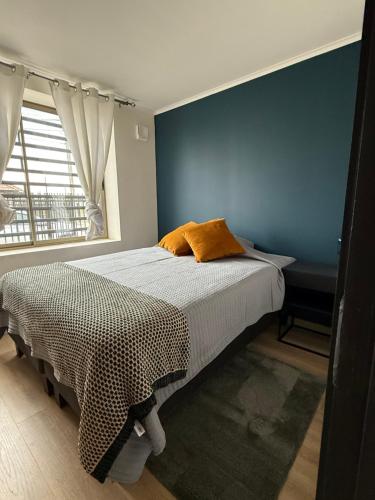 a bedroom with a bed with a blue wall at Cómoda casa con 3 habitaciones de lujo en Talca in Talca