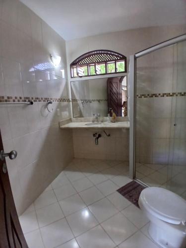 a bathroom with a shower and a sink and a toilet at Casa charme pipa in Pipa