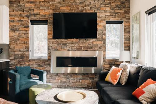 a living room with a tv on a brick wall at Lakefront - Trails - Skiing - Views - Georgetown in Georgetown
