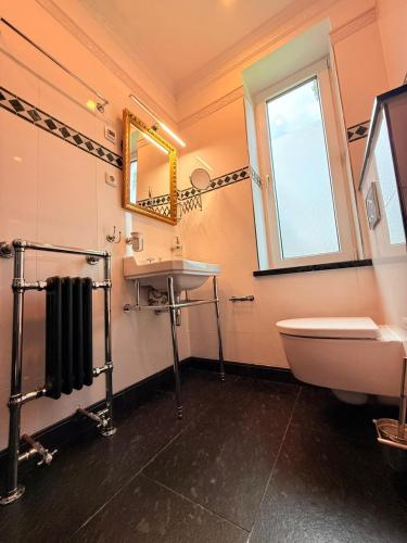 a bathroom with a sink and a toilet and a window at Whisperwood Apartment in Colnrade