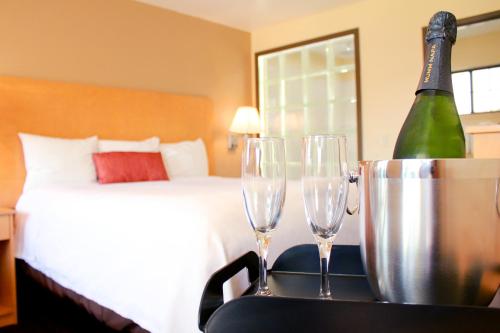 a bedroom with a bed and two wine glasses on a table at Travelodge by Wyndham Vallejo in Vallejo