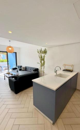 a kitchen and living room with a sink and a couch at Ayla Oasis Luxury Chalets - Azure & Golf in Aqaba