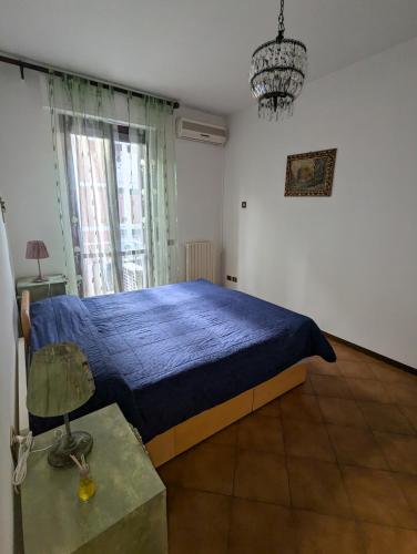 a bedroom with a blue bed and a window at Casafiorella in Monza