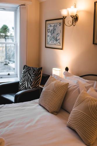 a bedroom with a bed with pillows and a window at Dykeneuk rooms in Hartburn