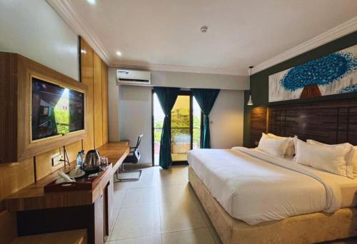 a hotel room with a large bed and a desk at Marcsons Hotels and Resorts in Limbe