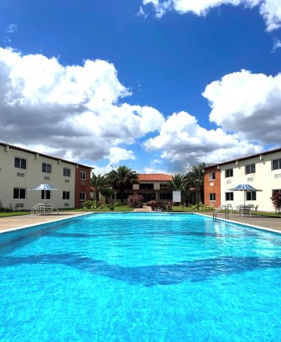 a large blue swimming pool with buildings in the background at Hotel Kariña Punta de Mata in Punta de Mata