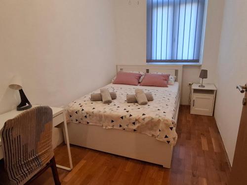 a bedroom with a bed and a desk and a window at Lovran centar, apartman Gega in Lovran