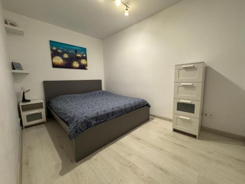 a small bedroom with a bed and a dresser at Apartment Pitesti in Piteşti