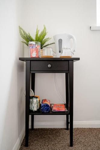 a black table with a plant on top of it at Cheerful and Cosy Double Room in Belfast