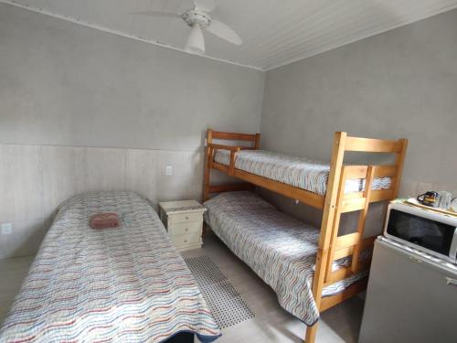 a bedroom with two bunk beds and a bed at Quarto Paulínia 2 in Paulínia